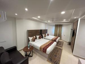 a bedroom with a large bed and a couch at Hotel President in Agra