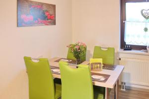 a dining room with a table and green chairs at Spreemitte in Lübbenau