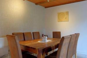 a dining room with a wooden table and chairs at Dat lütte Hus in Dorum