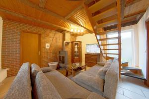 a living room with a couch and a staircase at Dat lütte Hus in Dorum