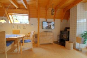 a dining room with a table and a television at SV2 Opi-Huck-Stroot 37 in Dorum-Neufeld
