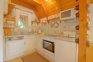 a kitchen with white appliances and wooden ceilings at SV2 Opi-Huck-Stroot 37 in Dorum-Neufeld