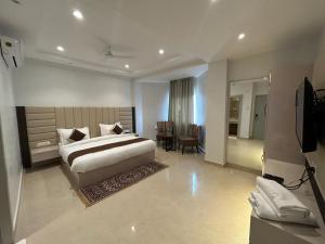 a large bedroom with a bed and a table at Hotel President in Agra