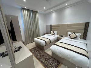 a hotel room with two beds and a television at Hotel President in Agra +2 photos