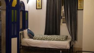 a small bed in a room with a window at Riad Dar Afram in Essaouira