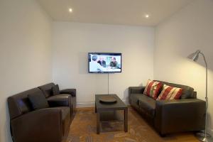 a living room with a couch and a tv on the wall at NS 6 Strandläufer Wremen in Wremen