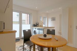 a kitchen and dining room with a wooden table and chairs at NS 6 Strandläufer Wremen in Wremen