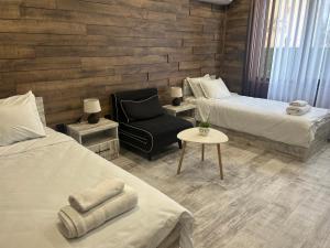 a room with two beds and a chair and a table at Къща за гости Бъчвата in Elkhovo