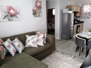 a living room with a couch and a kitchen at Luna Luxury Living in Nelspruit
