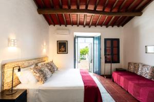 a bedroom with a white bed and a couch at Eighteen21 Houses - Casa dos Condes in Cano