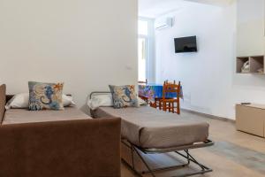a living room with two beds and a chair at Salaqua Bed and Breakfast in Torre Mozza