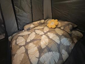 a teddy bear laying on a bed in a tent at Stay Like a Local เต็นท์บ้านเรา in Chiang Mai