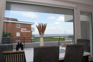 a dining room with a view of the ocean from a window at Hanseatic 204 in Duhnen