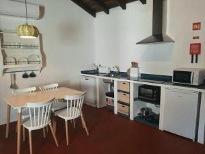 a kitchen with a table and a table and chairs at Casas do Hastim in Golegã