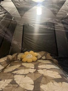 a stuffed animal laying on a bed in a tent at Stay Like a Local เต็นท์บ้านเรา in Chiang Mai