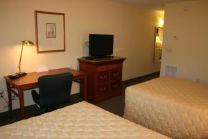 Una habitación de hotel con dos camas y un escritorio con una computadora. en Affordable Suites of America Augusta, en Augusta
