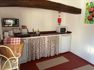 a kitchen with a counter with a sink and a microwave at Casas do Hastim in Golegã +12 photos