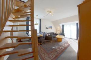 a living room with a wooden spiral staircase in a house at KD2-07 Schiffsjunge in Dorum-Neufeld