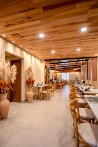 a restaurant with wooden ceilings and tables and chairs at Hotel Veneza in Itabuna