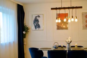 a dining room with a table and blue chairs at RK Private Residence in Trautmannsdorf an der Leitha +20 photos