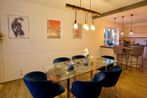 a dining room with a glass table and blue chairs at RK Private Residence in Trautmannsdorf an der Leitha