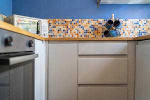 a kitchen with a counter top with a microwave at Thyme Cottage in Beccles +5 photos