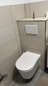 a bathroom with a white toilet with two rings on it at Wohnung im Zentrum von Gaggenau! in Gaggenau +8 photos