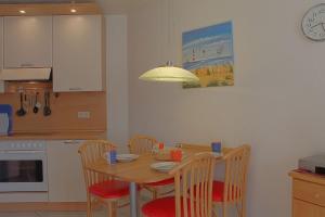 a kitchen with a wooden table with chairs and a dining room at LT 33a Bungalow Max in Dorum-Neufeld