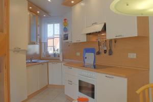 a kitchen with white cabinets and a blue appliance at LT 33a Bungalow Max in Dorum-Neufeld