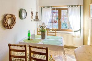 a dining room with a table with chairs and a clock at Blütenzauber in Stennewitz