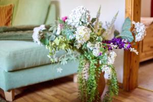 a vase filled with flowers sitting next to a couch at Blütenzauber in Stennewitz