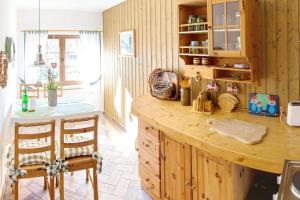 a kitchen with a wooden counter and two chairs at Blütenzauber in Stennewitz +17 photos