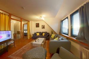 a living room with couches and a flat screen tv at KA6 Haus Küstenzeit in Wremen
