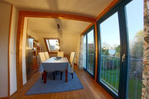 a dining room with a table and large windows at KA6 Haus Küstenzeit in Wremen