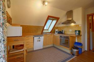 a kitchen with wooden cabinets and a white stove top oven at KA6 Haus Küstenzeit in Wremen +8 photos