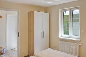 a bedroom with a white cabinet and a window at Quartier Spreestraße - App 5 in Burg +4 photos