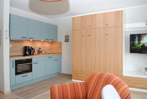 a kitchen with blue cabinets and an orange chair at Hanseatic 512 in Duhnen