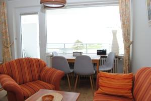 a dining room with a table and chairs and a window at Hanseatic 512 in Duhnen
