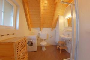 a bathroom with a toilet and a sink and a washing machine at SV3 Mellumplate 56 in Dorum-Neufeld
