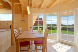 a kitchen and dining room with a wooden table and chairs at SV3 Mellumplate 56 in Dorum-Neufeld