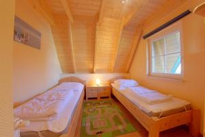 two beds in a room with a wooden ceiling at SV3 Mellumplate 56 in Dorum-Neufeld