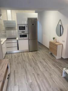 a large kitchen with stainless steel appliances and wood floors at Casita Mona Marcoin in Toledo