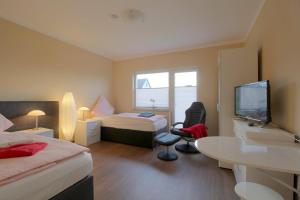 a hotel room with two beds and a flat screen tv at Gästehaus Dorum 03 in Dorum