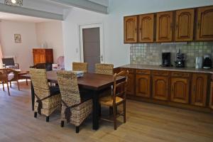a kitchen with a wooden table and chairs at La fontaine in Saint-Mathieu +9 photos