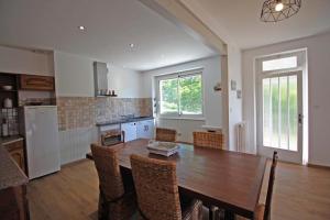 a kitchen and dining room with a table and chairs at La fontaine in Saint-Mathieu
