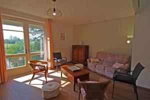 a living room with a couch and chairs at La fontaine in Saint-Mathieu