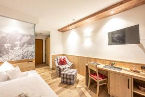 a hotel room with a bed and a desk at Hotel Garni Schellenberg in Oberstdorf