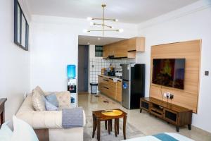 ein Wohnzimmer mit Sofa und eine Küche in der Unterkunft Sunset Stays near UN, Two Rivers & Village Market with Gym & Pool in Ruaka