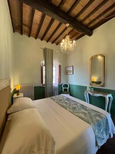 a bedroom with a large bed and a chandelier at B&B Osteria Del Vicario in Certaldo
