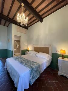 a bedroom with a large bed and a chandelier at B&B Osteria Del Vicario in Certaldo